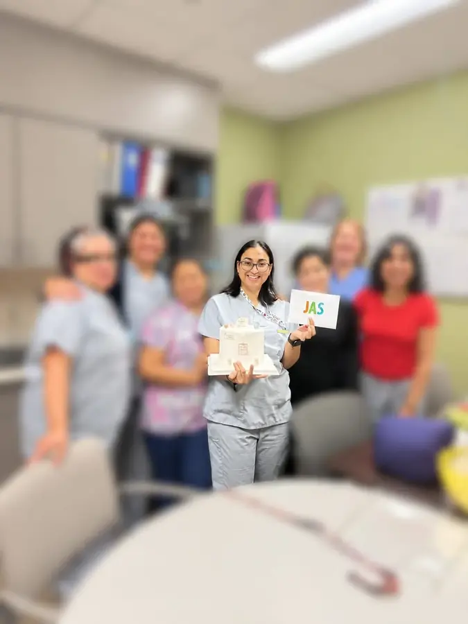 Jasraj holding a farewell cake and a card from her bedside nursing team