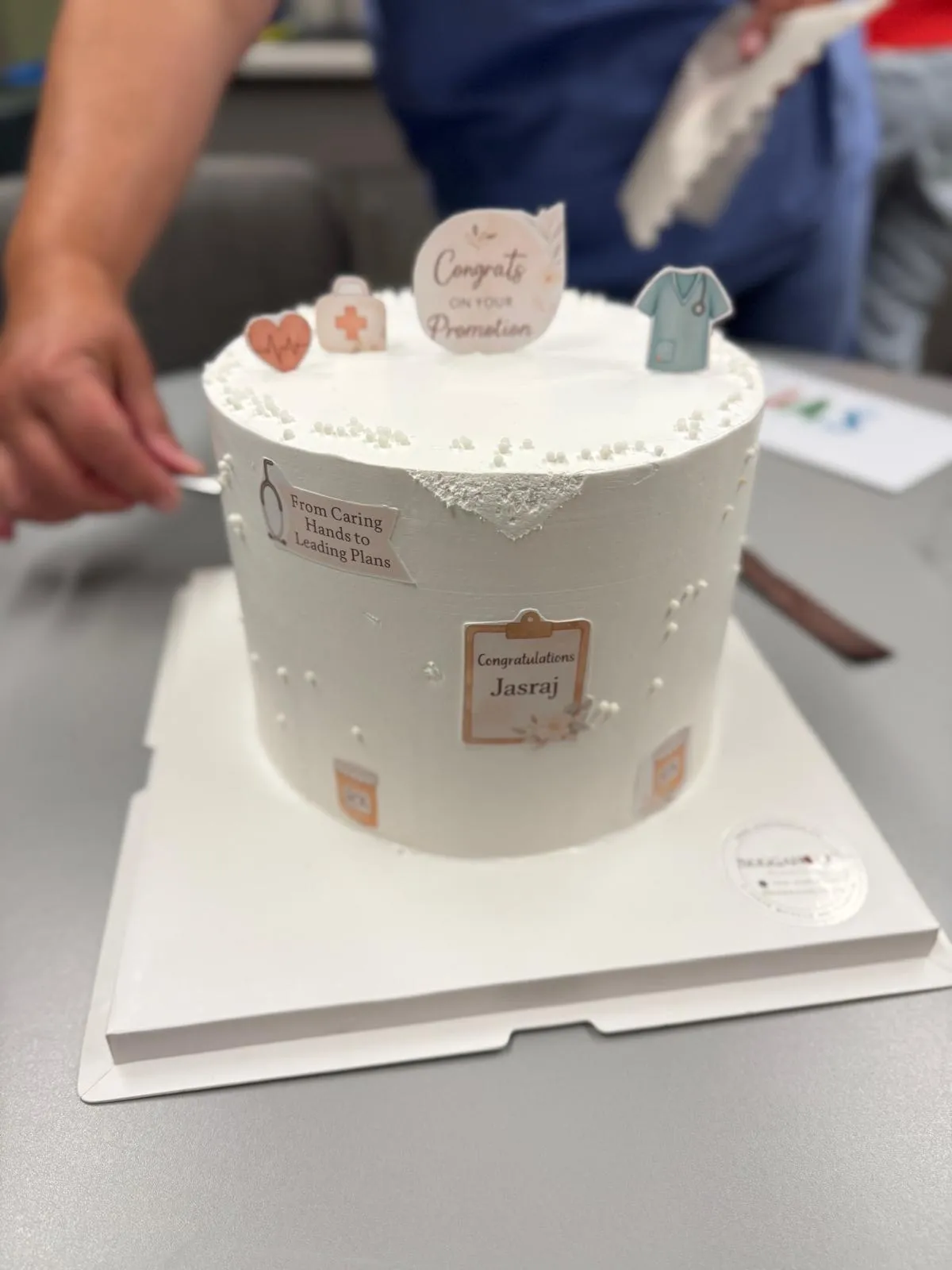 Jasraj holding a celebration cake surrounded by her nursing team