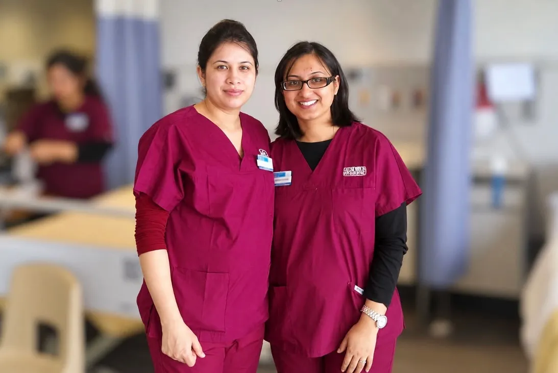 Jasraj and a colleague in scrubs standing together on a hospital unit